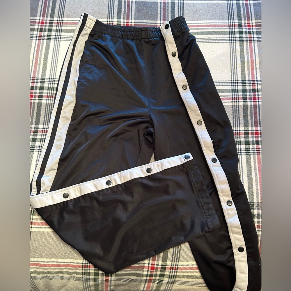 Men’s Sportek polyester track pants with snap closing along legs.